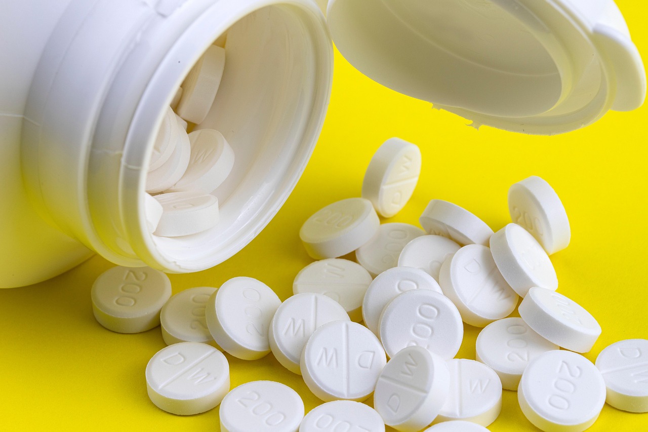 Pharmaceutical tablets beside a medicine container